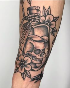 a man's arm with a bottle and skull tattoo on the left side of his leg