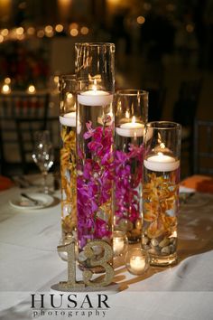 candles and flowers in glass vases on a table at a wedding reception for two