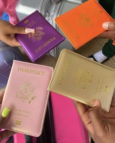 three people are holding up their passport covers