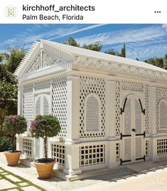 a white house with potted plants in front of it