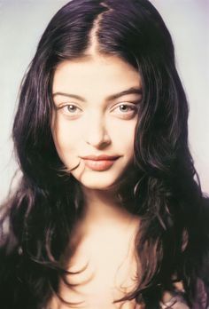 a woman with long dark hair is making a funny face while posing for the camera