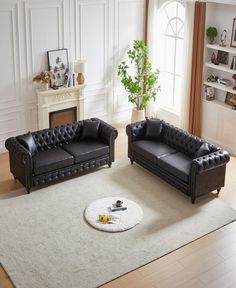 two black leather couches sitting on top of a white rug