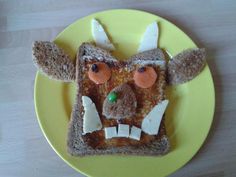 a piece of bread that has been made to look like a face on a yellow plate