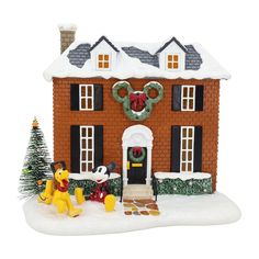 a toy house with a christmas wreath on the front door and winnie the pooh figurine