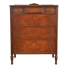 a wooden dresser with three drawers and two pulls on the bottom drawer, against a white background