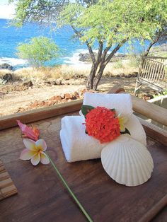 towels and flowers are sitting on a wooden tray