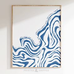 a blue and white painting hanging on the wall