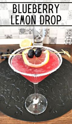 the blueberry lemon drop cocktail is garnished with blackberries