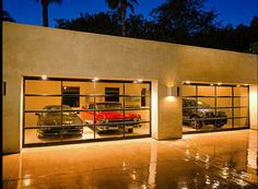 two cars are parked in the garage with their doors open and lights on at night