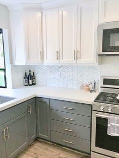 a kitchen with gray cabinets and white counter tops