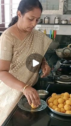 a woman standing in front of a pan filled with food