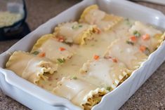 a casserole dish with meat and vegetables in it sitting on the counter top