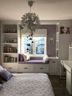 a bedroom with built in bookshelves and a window seat next to the bed