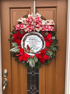 a wreath on the front door decorated with poinsettis