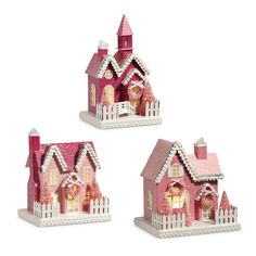 three small pink houses with white pickets on the front and back of each house