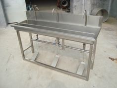 a stainless steel sink with two faucets on each side and three sinks below