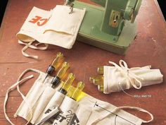 an old sewing machine and some bottles on the ground next to bags with labels labeled