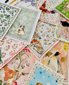 many different colored cards with birds and flowers on them are scattered around the table top