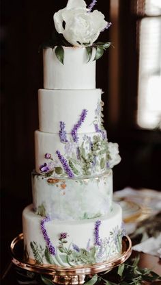 a wedding cake decorated with flowers and greenery