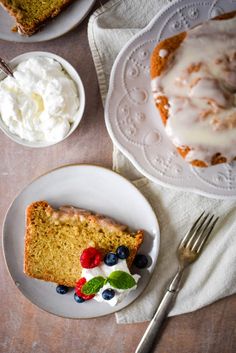 a piece of cake on a plate with whipped cream next to it and two bowls of fruit