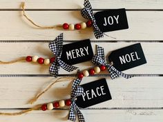 three black and white christmas tags with red, white and blue beads hanging from twine