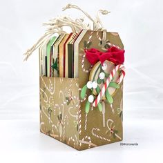 an origami christmas bag with candy canes and cookies in it, on a white background