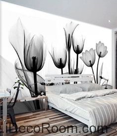 a bed sitting in front of a wall with black and white flowers on it's side