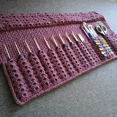 a crocheted placemat with knitting tools on it, sitting on a couch