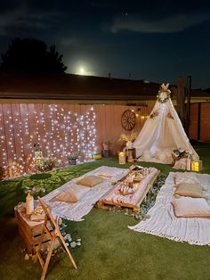 a teepee tent set up in the middle of a yard with pillows and blankets on it