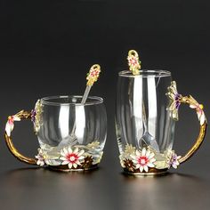 two glass cups with gold handles and flowers on them