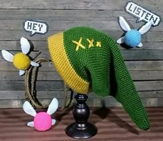 there is a knitted hat on top of a stand with other items around it