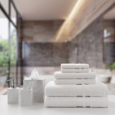 a stack of white towels sitting on top of a counter