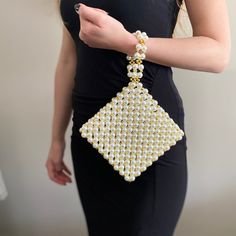 Elevate your evening ensemble with our meticulously crafted wristlet clutch, adorned with delicate pearl beads interspersed with shimmering gold accents. Handmade with care, this exquisite piece exudes elegance and sophistication, perfect for both evening affairs and bridal occasions. This pearl clutch bag, which is a delightful design that you can pair with your dresses, will also serve as a perfect accessory for special occasions like wedding day or bridal showers.  🤍For your friends who are soon to become brides, this would make a perfect gift option. Materials: High Quality Pearl and Gold beads. Width: 22 cm / 8.66" Height:  22 cm / 8.66"  Height with strap: 31 cm / 12.20" You can fit your personal items such as lipstick, mini cardholder, and keys in your bag. 💃🏼If the order is read Pearl Bags, Unusual Handbags, Pearl Purse, Pearl Clutch Bag, Pearl Handbag, Bridesmaid Clutch