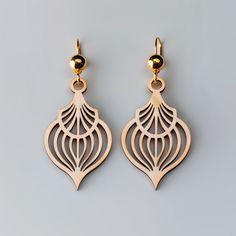 two pairs of gold toned earrings with intricate designs on the front and back of them