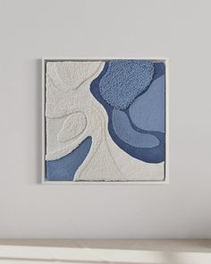 a white and blue painting hanging on the wall