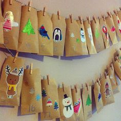 brown paper bags decorated with christmas images hanging from clothes pins