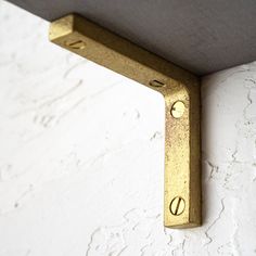 a close up of a metal object on a white wall with holes in the middle