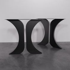 a black table with curved legs on concrete floor