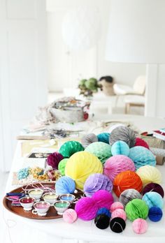 many balls of yarn are sitting on a table in front of a lamp and other items