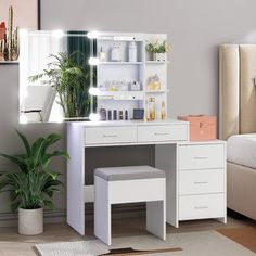 a bedroom with a bed, plant and vanity mirror in it's center area