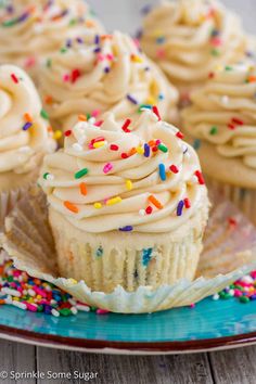 cupcakes with white frosting and sprinkles on a blue plate