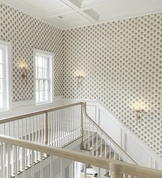 the stairs in this house are lined with decorative wallpaper and chandelier lights