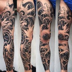 the legs are covered in black and grey ink, with waves on each side of them