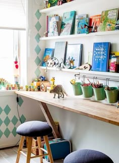 two stools sit in front of a desk with books on the shelves and children's toys