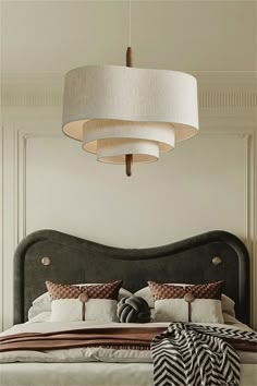 a bedroom with a large bed and two lamps hanging from the ceiling