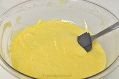 a mixing bowl with yellow batter in it