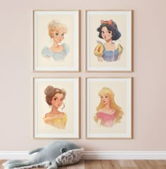 three disney princesses are hanging on the wall next to a stuffed animal and two framed pictures