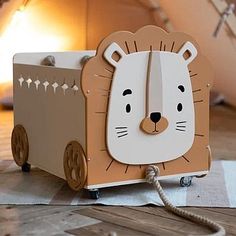 a wooden toy truck with a lion face on it