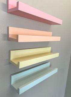 three different colored shelves are hanging on the wall