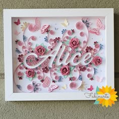 a white frame with pink flowers and butterflies in the shape of an i love you sign